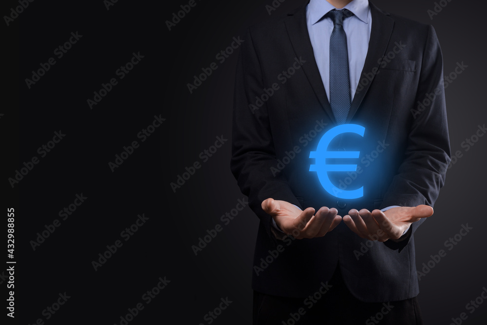 Businessman holds money coin icons EUR or Euro on dark tone background..Growing money concept for business investment and finance Businessman holds money coin icons EUR or Euro on dark tone background..Growing money concept for business investment and finance