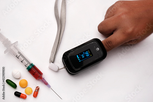 Measurement of blood oxygen saturation with a pulse oximeter. Injection and Medicines in the background. photo