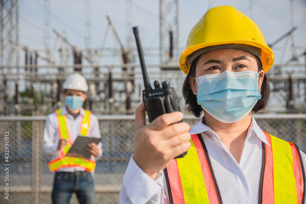Two Engineer wear facemask teamwork are working industrial electricity power plant , Teamwork wear mask protect coronavirus Two Engineer wear facemask teamwork are working industrial electricity power plant , Teamwork wear mask protect coronavirus