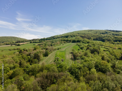 aerial drone flight photo of green hills  meadows and fresh forest in Lower Austria at the edge of Vienna Woods on a sunny day