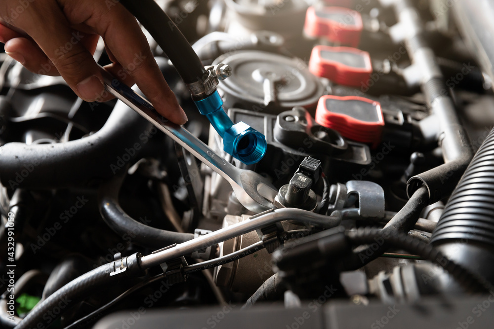 Obraz premium Auto mechanic man with wrench repair and maintenance to customer the engine a vehicle car hood in auto mechanics garage.