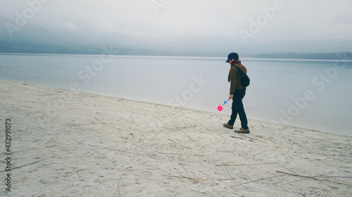 A man walking by the lake in Osorezan, Japan.    photo