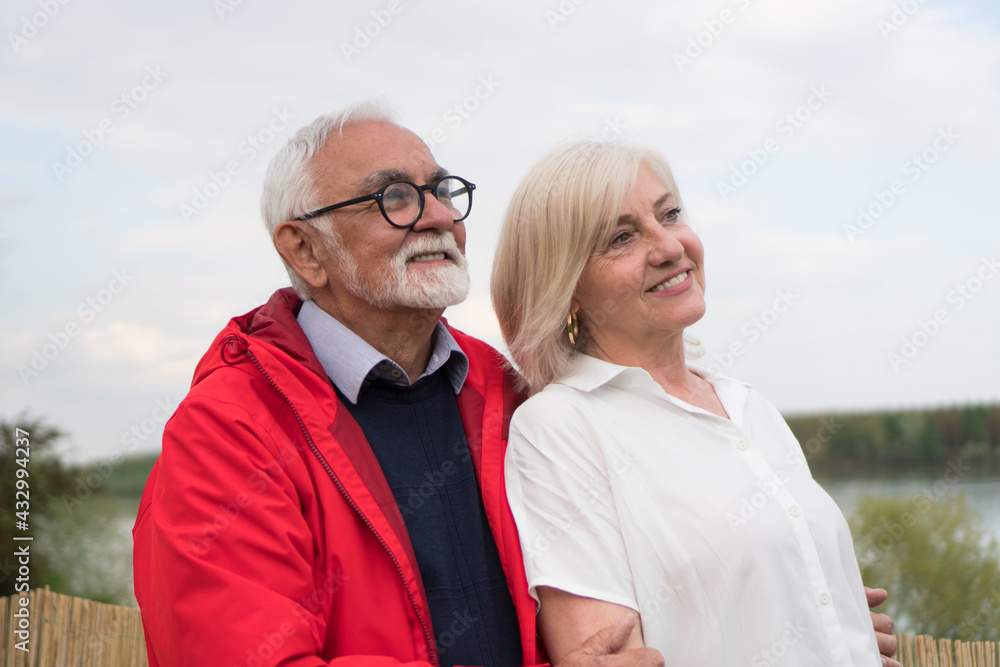 A good-looking senior couple is walking through the garden and enjoying the view. A good-looking senior couple is walking through the garden and enjoying the view.
