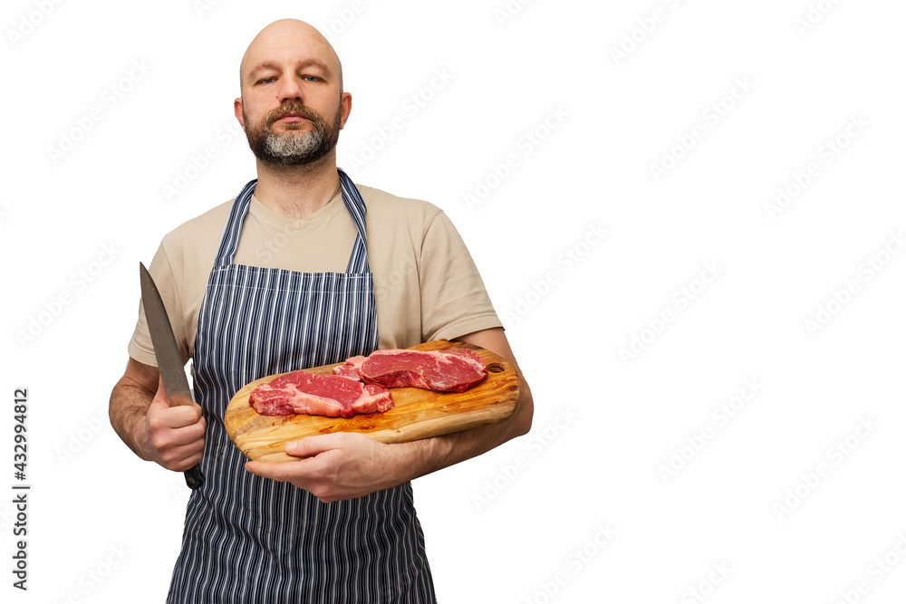 Bald butcher holding wooden cutting board with two fresh strip loin steaks. Meat industry. White isolated background. Prime cut of steak. The model is in t shirt and black and white apron, Bald butcher holding wooden cutting board with two fresh strip loin steaks. Meat industry. White isolated background. Prime cut of steak. The model is in t shirt and black and white apron,