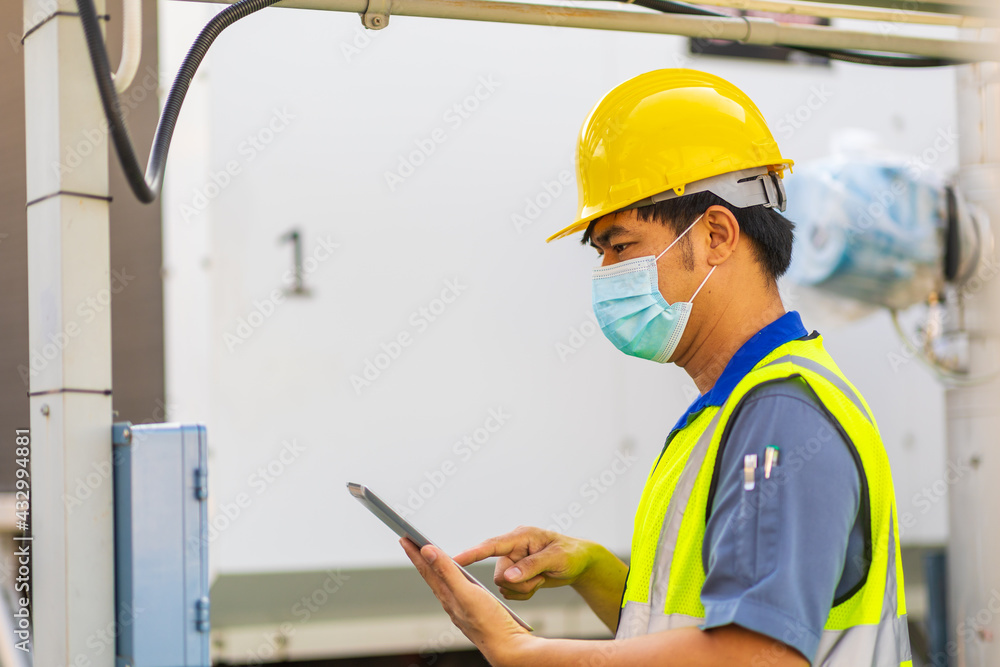 Engineer with safety helmet at the construction site typing on a digital tablet Engineer with safety helmet at the construction site typing on a digital tablet