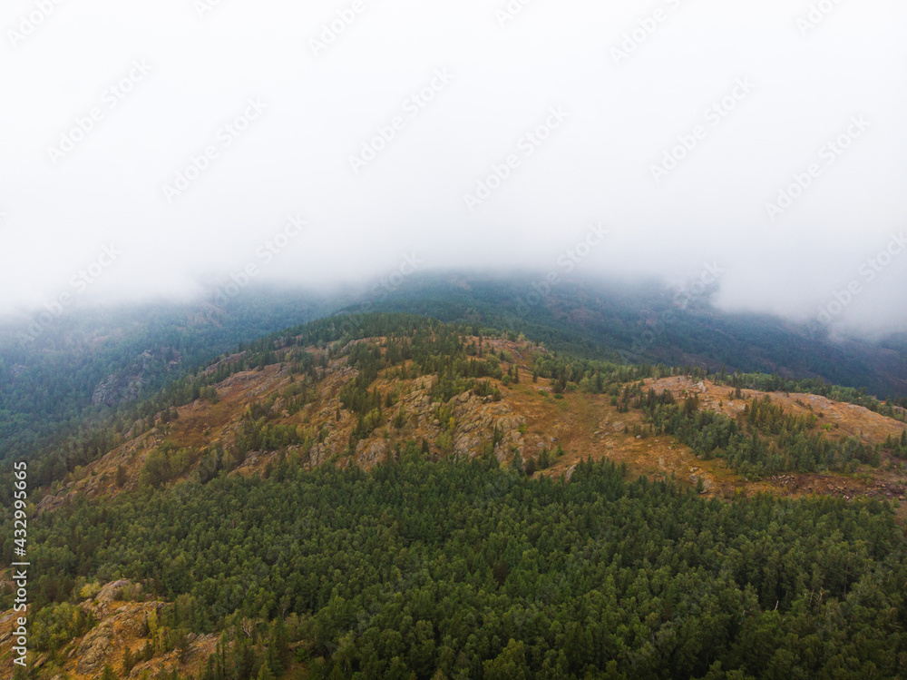 Foggy evergreen fir forest on a hilltop among the mountains of the National Park of the Republic of Bashkortostan on Lake Bannoye