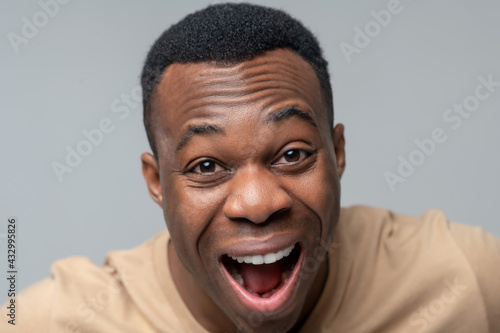 Face of adult dark man laughing with open mouth