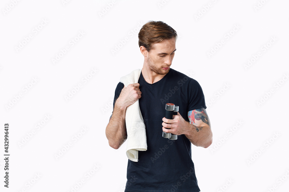 guy with a towel and dumbbells in his hand on a light background sports fitness bodybuilder guy with a towel and dumbbells in his hand on a light background sports fitness bodybuilder
