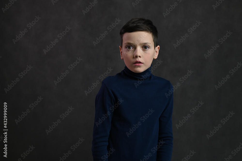 Portrait of a young caucasian guy scared on a gray background