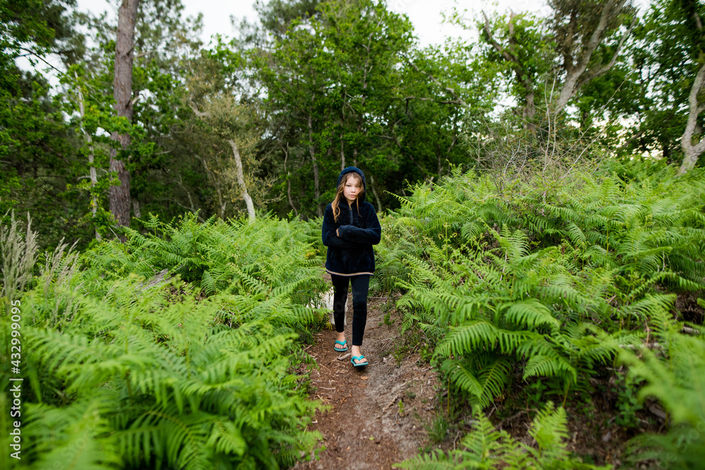 Obraz premium cute young girl walking in the forest with her dog