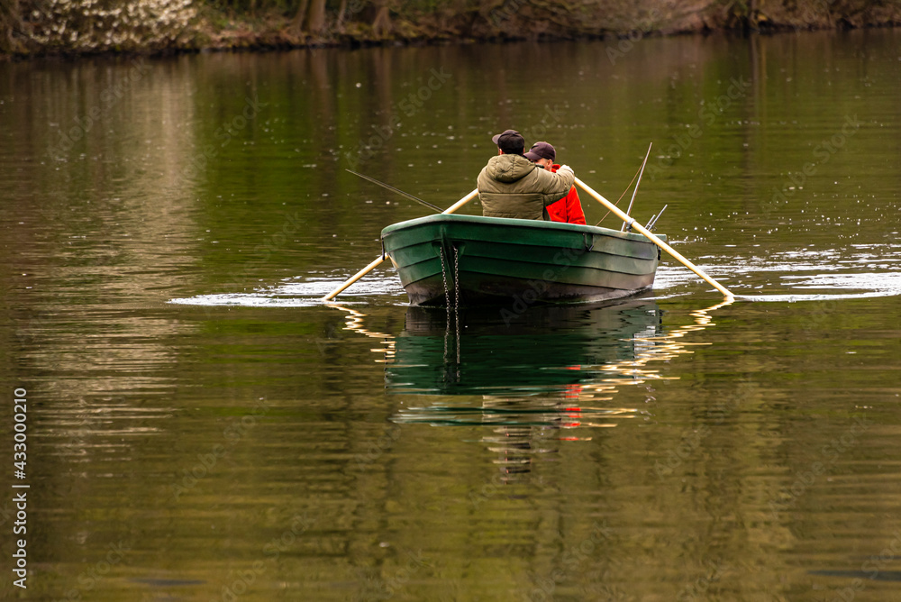 zwei Angler Männer rudern in einem Boot auf einem See