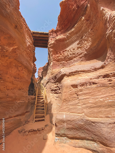 Mobile photography of Red Sandstone Canyon in the Sinai Desert, as textured background. Colored canyon with red rocks and wooden stairs. Egypt, desert, the Sinai Peninsula, Dahab.