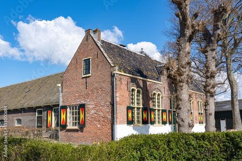 A beautiful old farmhouse with colorful shutters on the windows between the bulb fields around the city of Lisse © Emma
