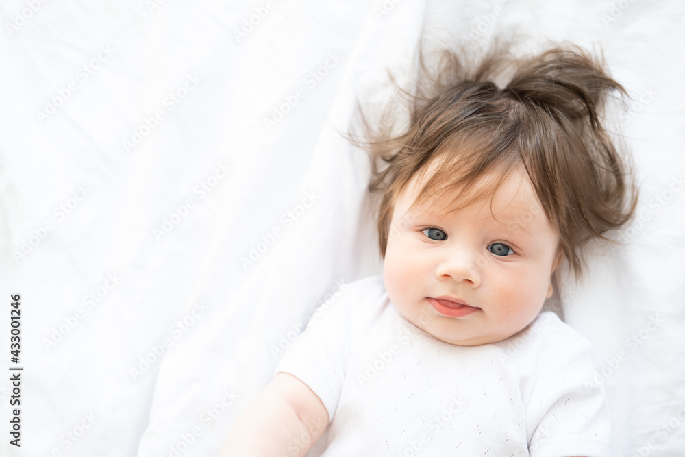 portrait of funny baby boy 6 month smiling and lying on a white bedding at home. portrait of funny baby boy 6 month smiling and lying on a white bedding at home.