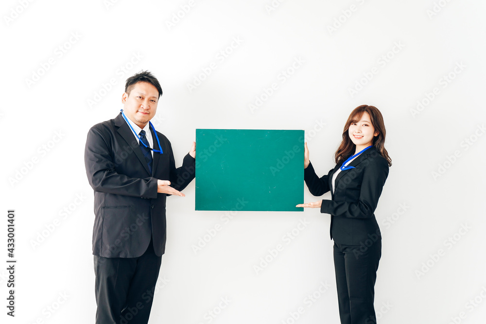 黒板を持つスーツを着た2人のビジネスパーソン 黒板を持つスーツを着た2人のビジネスパーソン