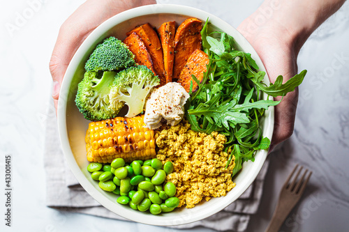 Vegan breakfast bowl - scrambled tofu, corn, beans, sweet potato and broccoli. Plant-based diet concept.