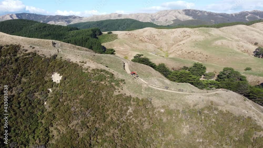 A slow orbiting shot of a digger making a road towards a wind farm. Meridian Energy Wind Farm, Makara Beach, New Zealand. A slow orbiting shot of a digger making a road towards a wind farm. Meridian Energy Wind Farm, Makara Beach, New Zealand.