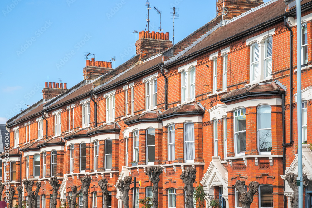 Row of identical traditional English red brick terraced houses around Crouch End area in London