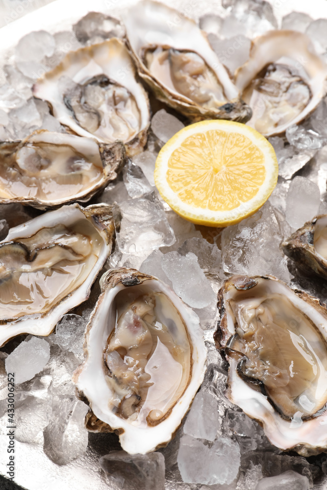 Delicious fresh raw oysters with lemon on ice, closeup Delicious fresh raw oysters with lemon on ice, closeup