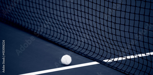  Tennis net and ball and hard court. Professional sport and tennis competition concept. Blue color filter
