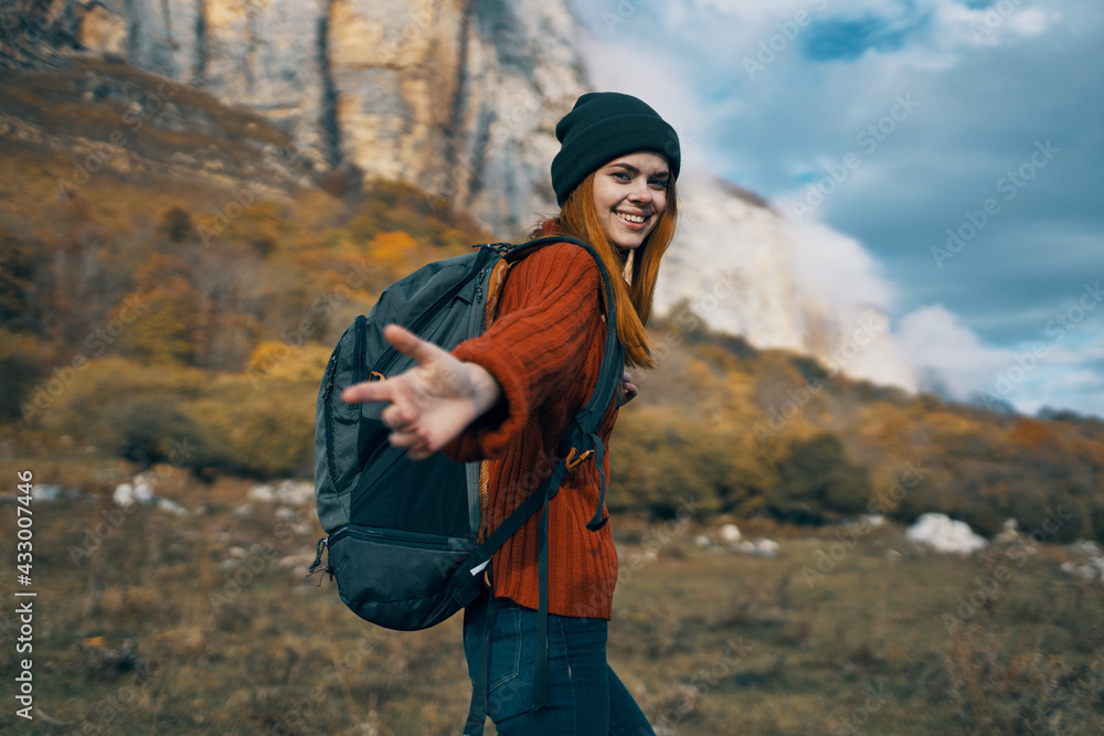 woman hiker with a backpack travels in the mountains outdoors in autumn fallen leaves woman hiker with a backpack travels in the mountains outdoors in autumn fallen leaves
