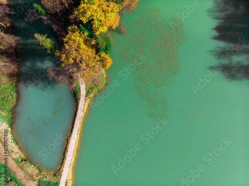 Top view of a beautiful blue lake among the autumn forest.