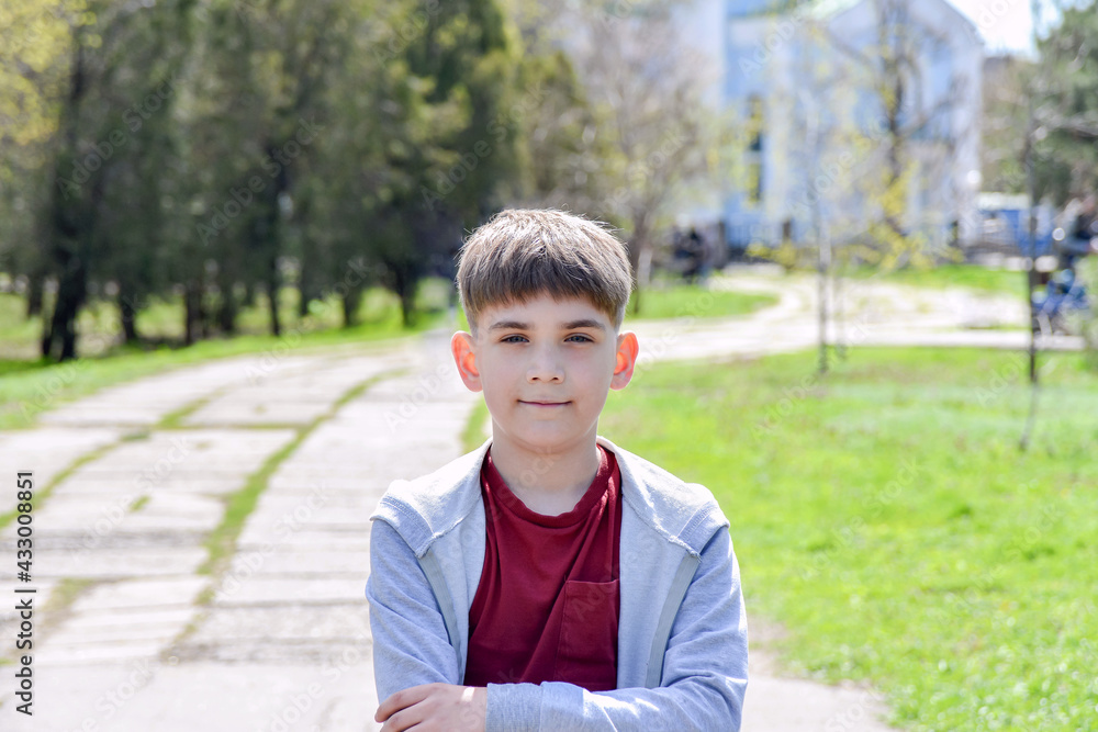 Child with a smart look in front of the background of the church in the fresh air.