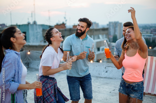 Group of happy friends having fun at rooftop party.