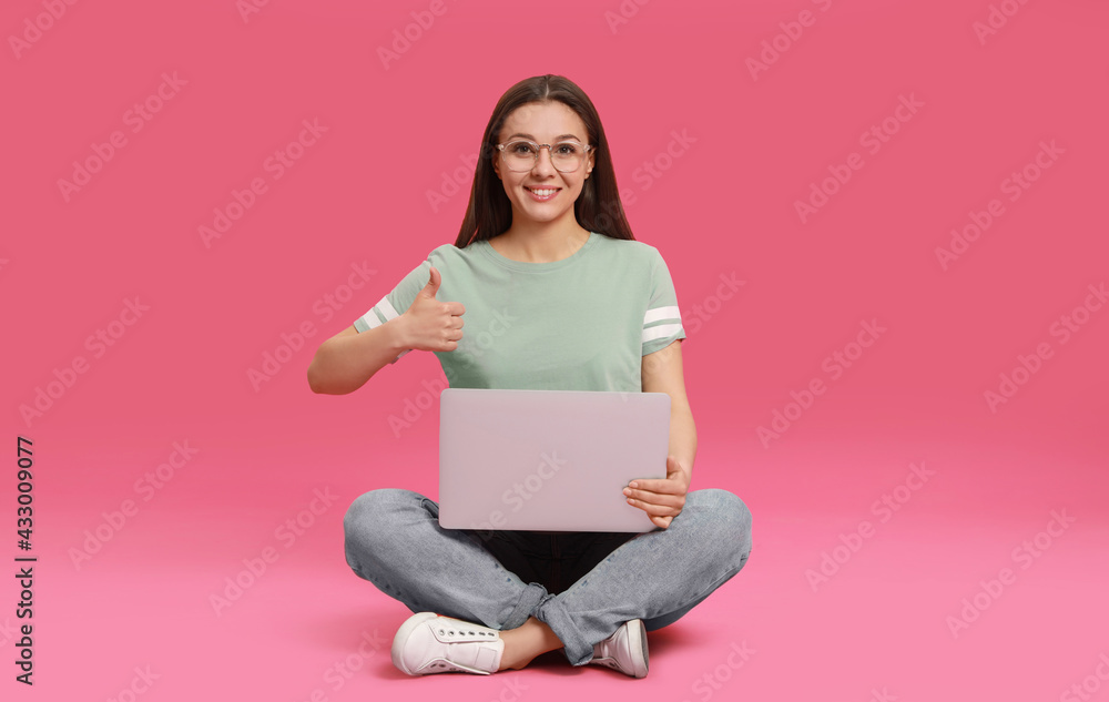 Young woman with modern laptop on pink background Young woman with modern laptop on pink background
