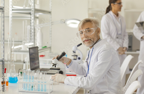 Medical doctor working in research lab. Portrait of a successful experienced senior scientist working under a microscope in a laboratory. Concept of science  chemistry  technology  biology and people