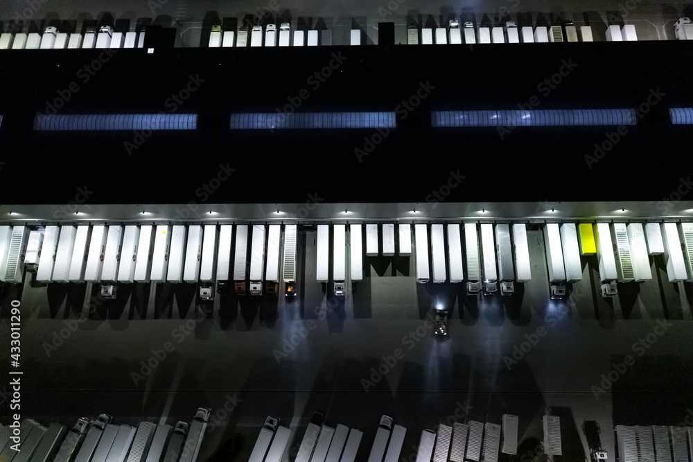 Aerial view of goods warehouse at Night. Logistics center in industrial city zone from above. Aerial view of trucks loading at logistic center. View from drone. Aerial view of goods warehouse at Night. Logistics center in industrial city zone from above. Aerial view of trucks loading at logistic center. View from drone.