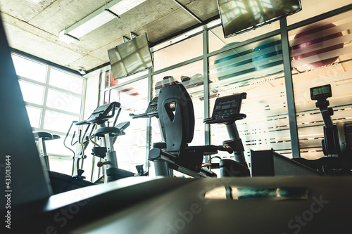 Running simulators in the gym interior opposite the window. Empty fitness rooms without people