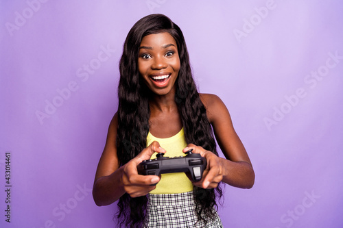 Photo of crazy funny dark skin lady enjoy playing game have good mood isolated on violet color background
