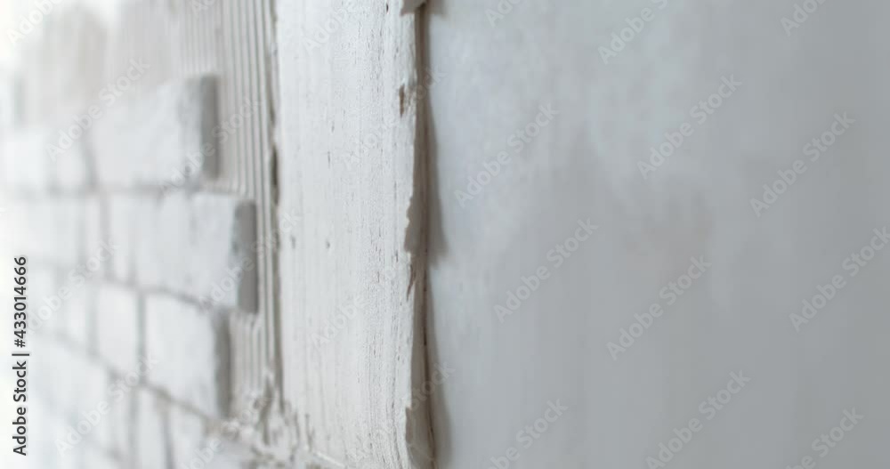 Home renovation. Unrecognizable construction worker laying facing bricks on the wall closeup, 4k slow motion Home renovation. Unrecognizable construction worker laying facing bricks on the wall closeup, 4k slow motion