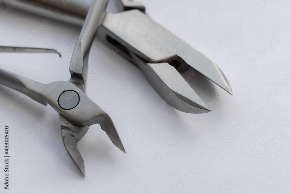 Metal steel nippers for pedicure and manicure. Macro photography. Manicure tools on a white background. Sterile instruments Metal steel nippers for pedicure and manicure. Macro photography. Manicure tools on a white background. Sterile instruments