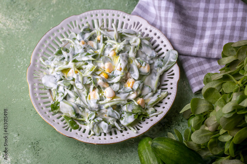 Purslane salad with yogurt in bowl on wooden background.