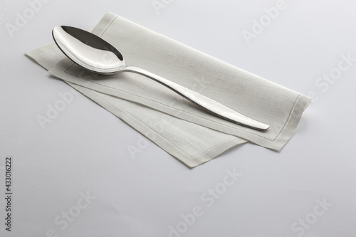 Cuchara sobre servilleta desechable sobre fondo blanco. Spoon on disposable napkin on white background.