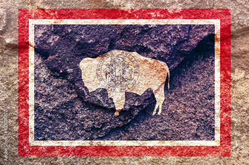 Aded Wyoming state flag icon pattern isolated on weathered solid rock wall background photo