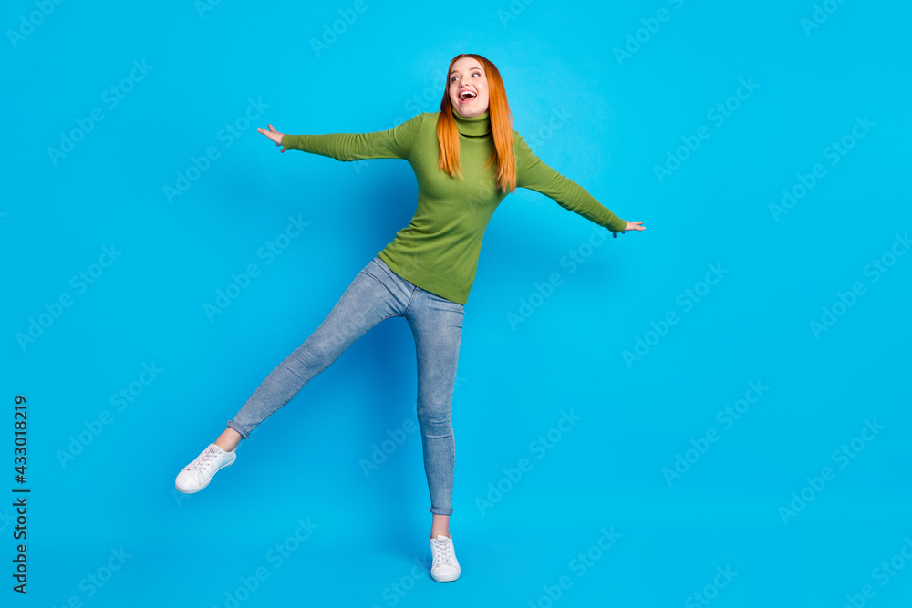 Full length body size view of attractive cheerful girl jumping having fun isolated over bright blue color background Full length body size view of attractive cheerful girl jumping having fun isolated over bright blue color background