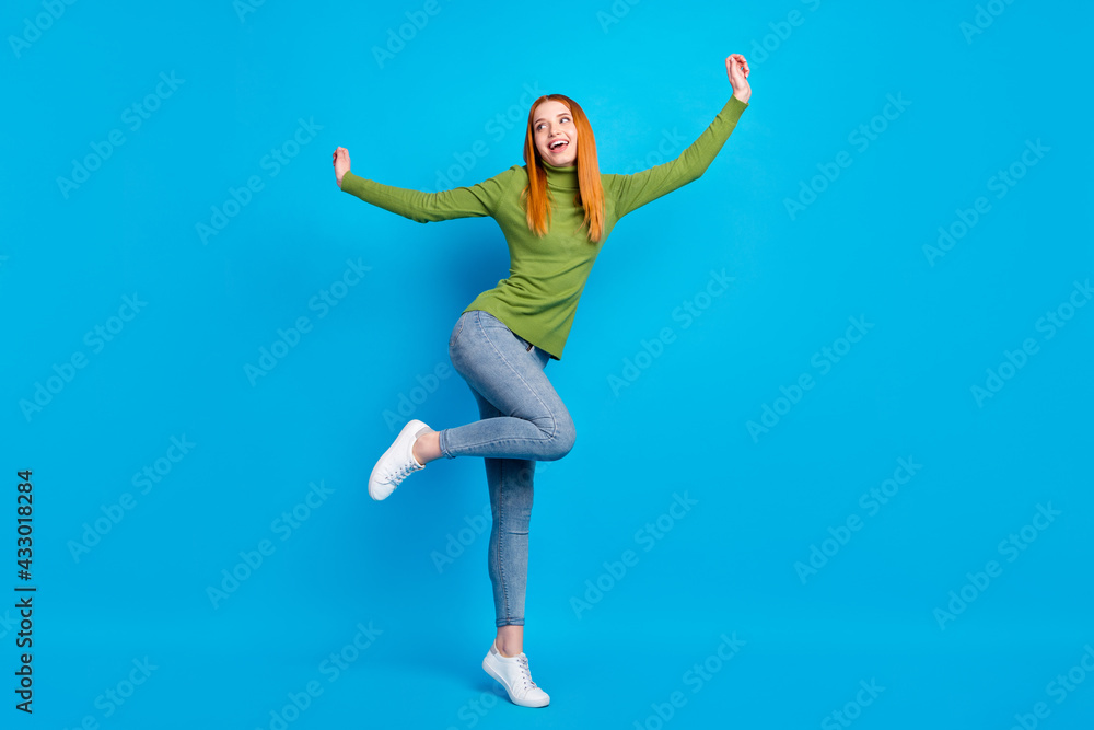 Full length body size view of pretty carefree cheerful funny girl jumping having fun dancing isolated over bright blue color background Full length body size view of pretty carefree cheerful funny girl jumping having fun dancing isolated over bright blue color background