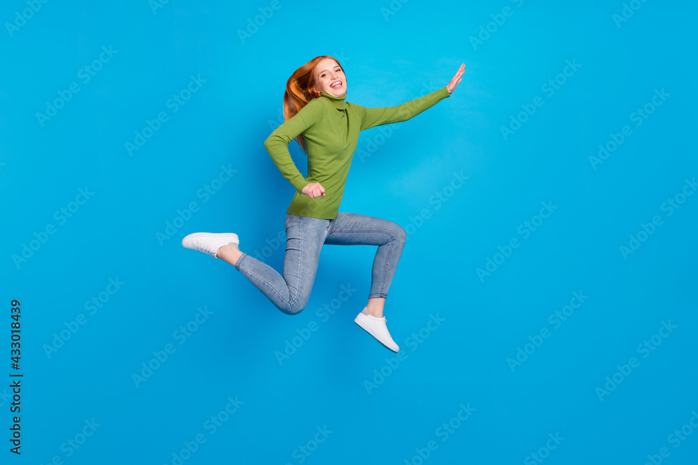 Full length body size view of attractive glad cheerful girl jumping running isolated over bright blue color background