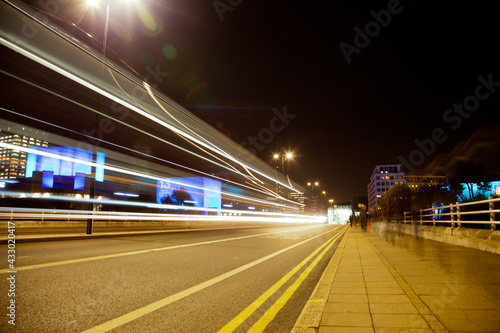 Long exposure picture people and traffic crossing a bridge at night