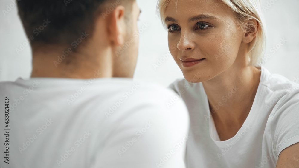 blonde woman looking at boyfriend on blurred foreground blonde woman looking at boyfriend on blurred foreground