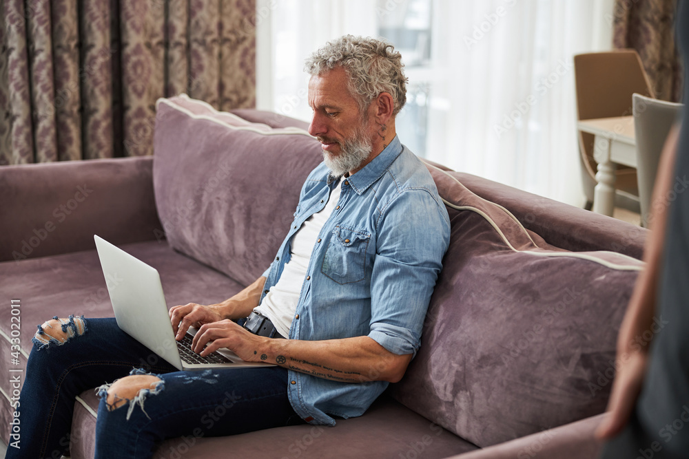 Attentive grey-haired male person using his laptop Attentive grey-haired male person using his laptop
