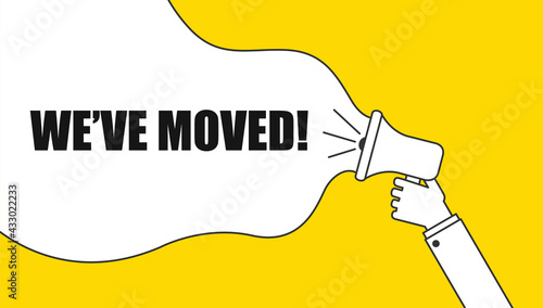 Male hand holding megaphone with We've moved speech bubble. Loudspeaker. Banner for business and marketing
