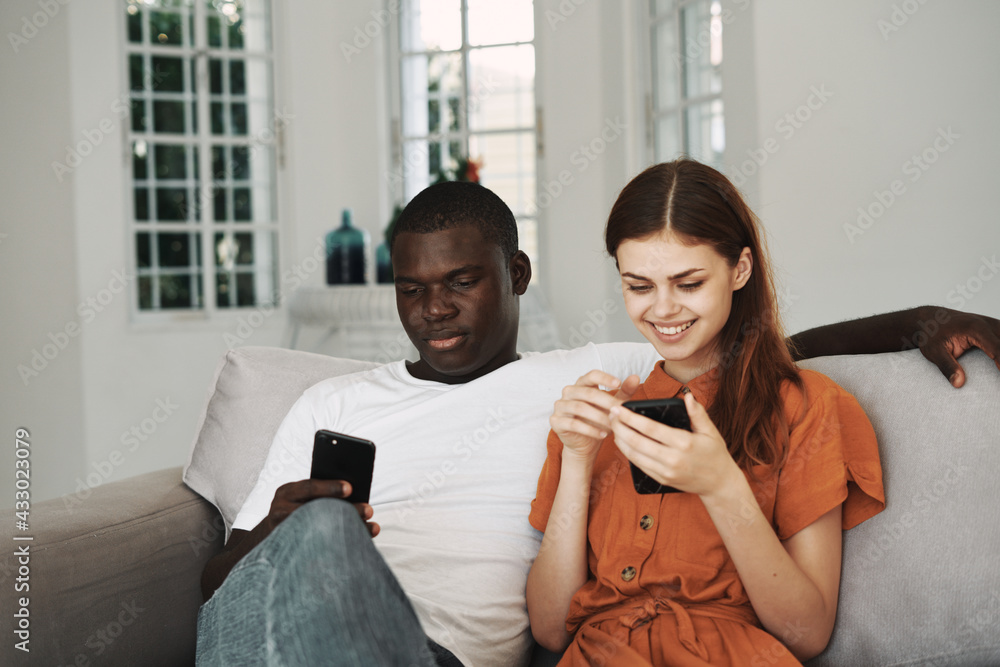 a man and a woman are sitting at home on the couch with phones in their hands internet