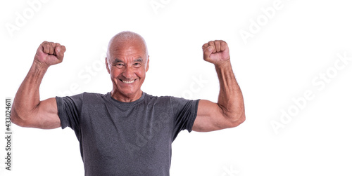 An elderly man, an athlete in excellent physical shape, celebrates a victory with cheerful emotions. On a white isolated background.