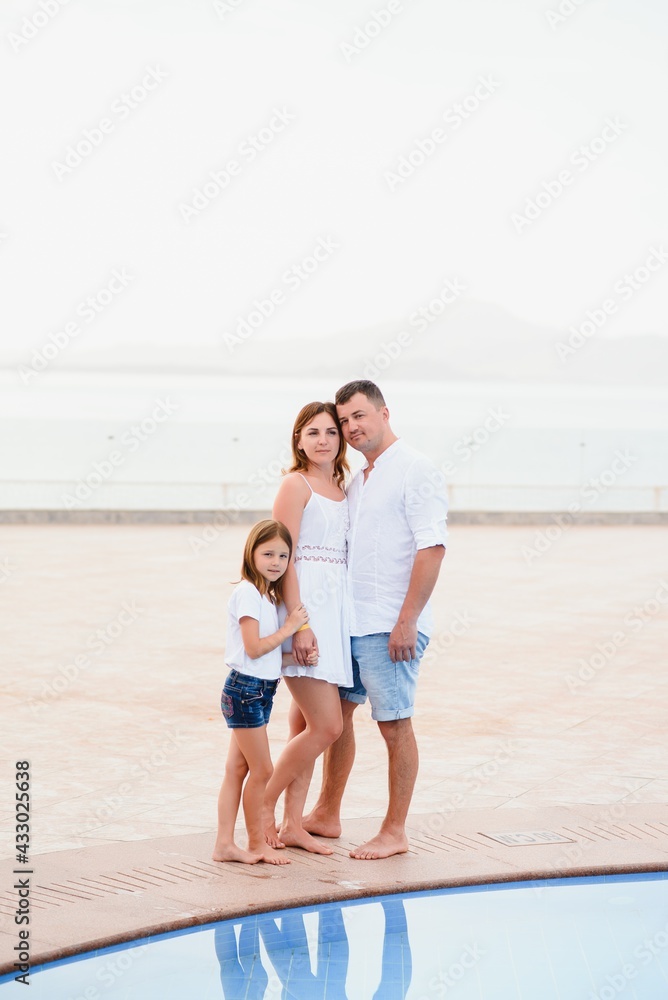 Happy family, summer resting near the pool. father mother and daughter Happy family, summer resting near the pool. father mother and daughter