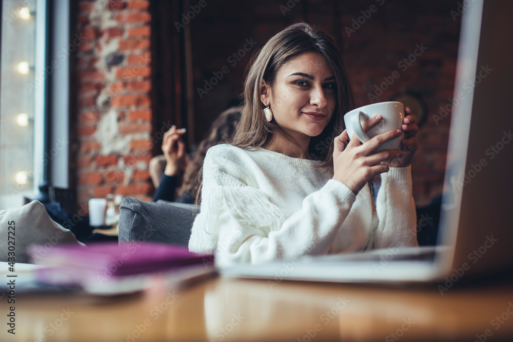 Satisfied woman drinking coffee in cafeteria - obrazy, fototapety, plakaty 