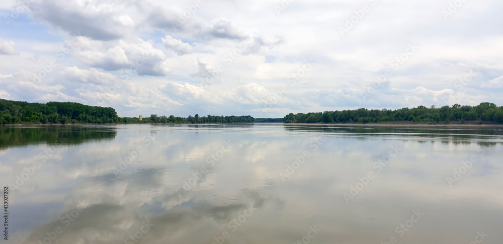 Landscape of a wide river with clouds on a gray, autumn day. Panorama.